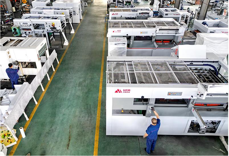 Workers work on the production line at a printing and packaging machinery manufacturing company in Y ...